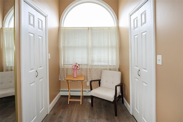 sitting room featuring baseboards, a baseboard heating unit, and wood finished floors
