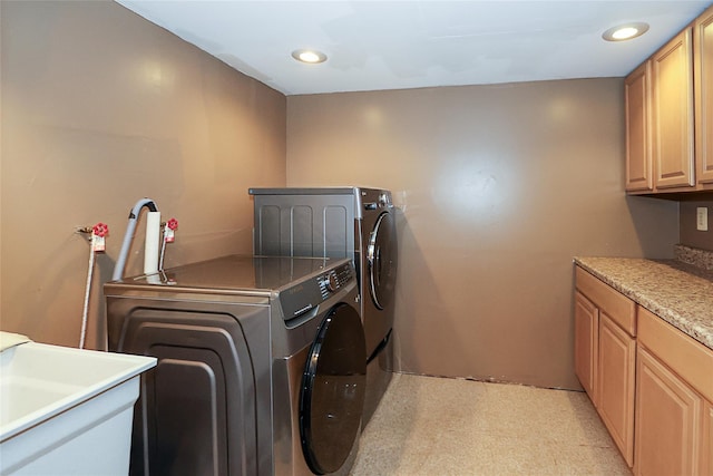 washroom featuring a sink, cabinet space, washer and dryer, and recessed lighting