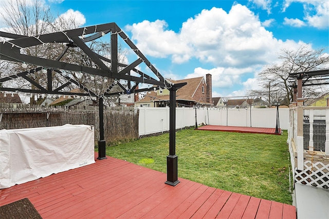 deck with a fenced backyard and a lawn