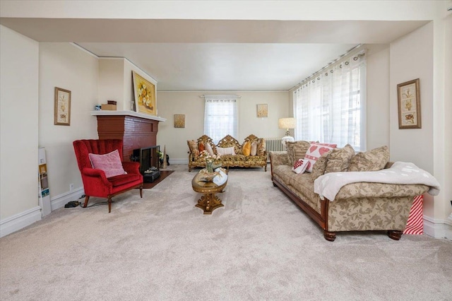 living area with baseboards, a fireplace, and carpet flooring