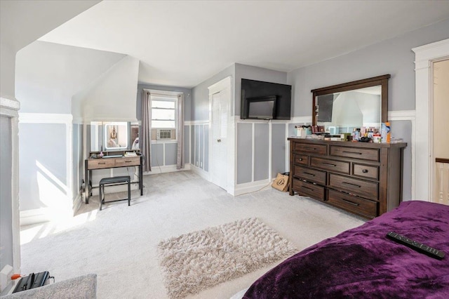 bedroom featuring carpet flooring, a wainscoted wall, and a decorative wall