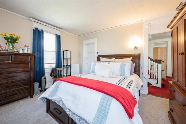 bedroom featuring light colored carpet and radiator