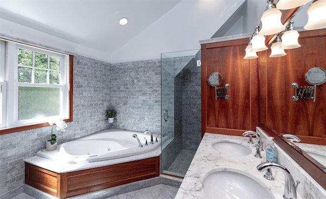full bath featuring a whirlpool tub, a sink, a stall shower, and vaulted ceiling