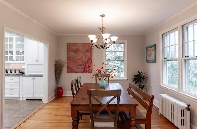 dining space with radiator heating unit, an inviting chandelier, plenty of natural light, and light wood-type flooring