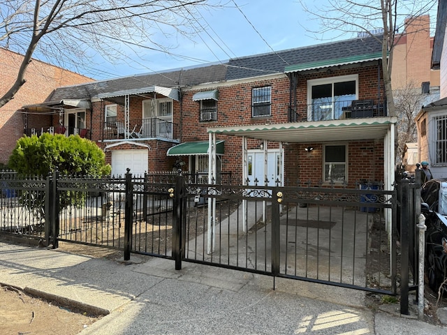 view of front of home featuring a shingled roof, a fenced front yard, and brick siding
