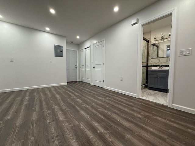 interior space featuring electric panel, baseboards, recessed lighting, and dark wood-style flooring