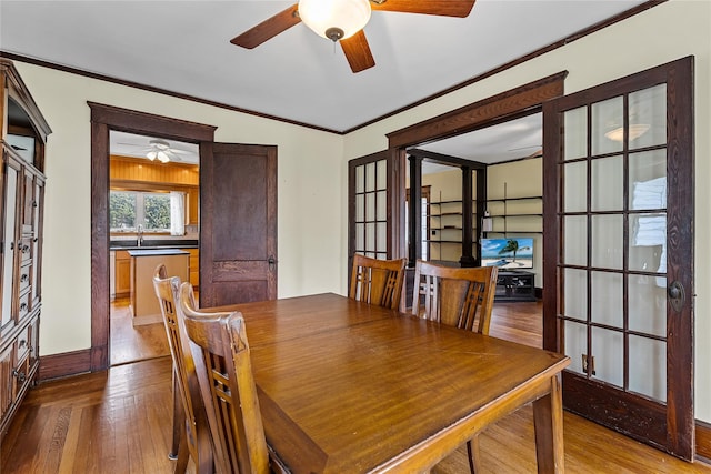 dining area featuring hardwood / wood-style flooring, crown molding, and ceiling fan