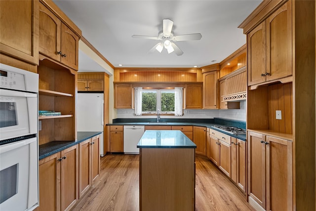 kitchen with white appliances, light wood-style flooring, a center island, a ceiling fan, and open shelves