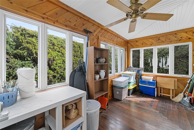 sunroom / solarium with wooden walls, hardwood / wood-style flooring, and lofted ceiling
