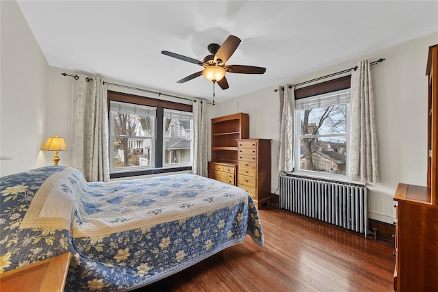 bedroom with radiator heating unit, a ceiling fan, and wood finished floors