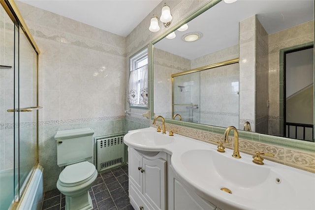 bathroom featuring a sink, tile walls, toilet, radiator, and tile patterned flooring