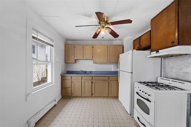 kitchen featuring a sink, a baseboard radiator, under cabinet range hood, white range with gas stovetop, and light floors