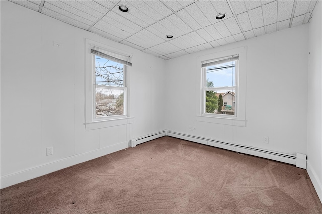 unfurnished room with carpet floors, a baseboard radiator, and a paneled ceiling