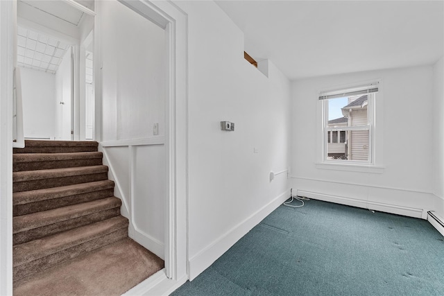 carpeted spare room featuring baseboards, stairway, and baseboard heating