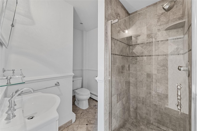 bathroom with toilet, a sink, a stall shower, a baseboard radiator, and tile patterned floors