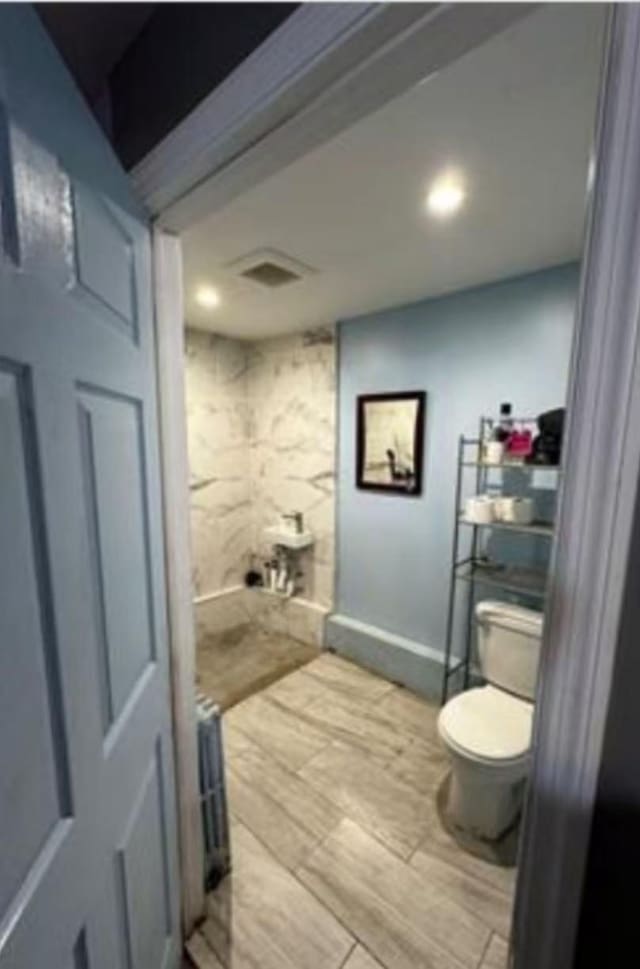 bathroom with visible vents, toilet, and wood finished floors