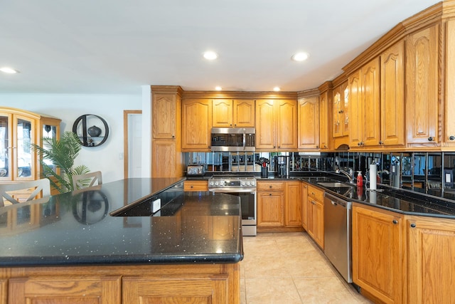 kitchen with light tile patterned flooring, brown cabinetry, and appliances with stainless steel finishes