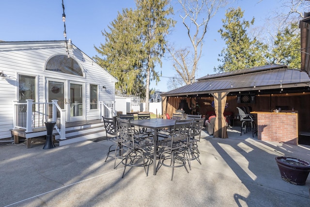 view of patio with fence, outdoor dining space, and outdoor dry bar
