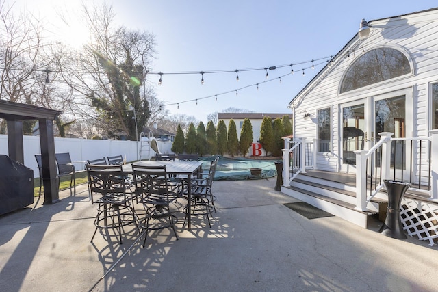 view of patio featuring a fenced backyard, a fenced in pool, grilling area, and outdoor dining space