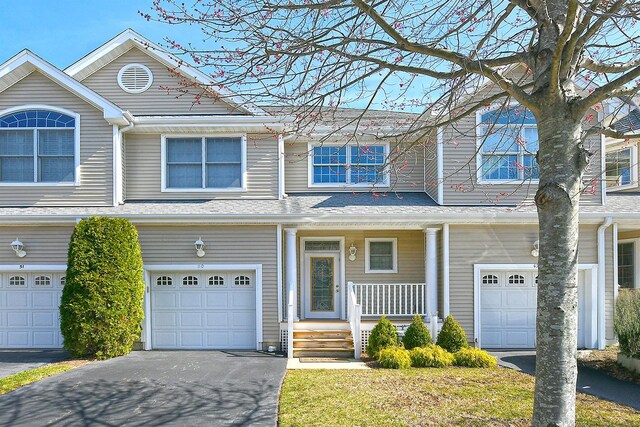multi unit property featuring driveway, covered porch, and an attached garage