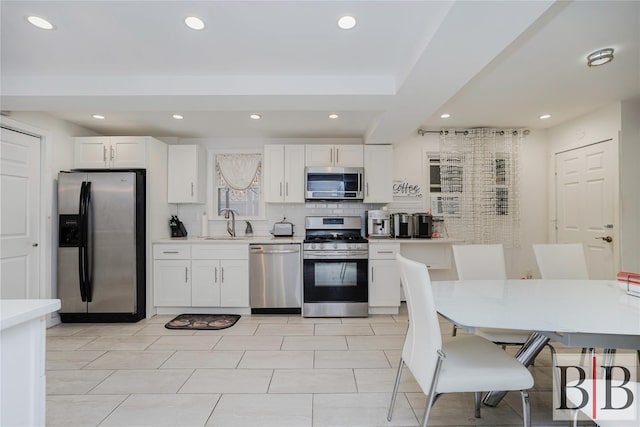2394 National Dr, Brooklyn, NY 11234 - kitchen with white cabinets, a sink, stainless steel appliances, and decorative backsplash