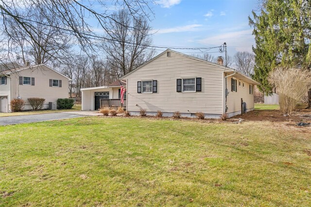 24 Patricia Ln, Washingtonville, NY 10992 - view of front of property featuring aphalt driveway, a front yard, a garage, central AC, and a chimney