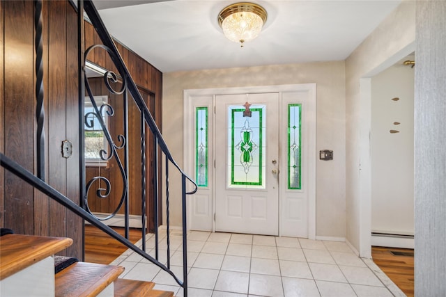 entryway featuring baseboards, stairs, baseboard heating, and light tile patterned floors
