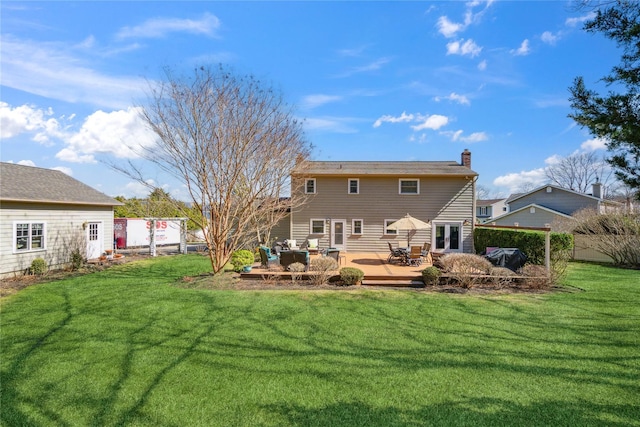 back of house with a lawn, a wooden deck, fence, and a chimney