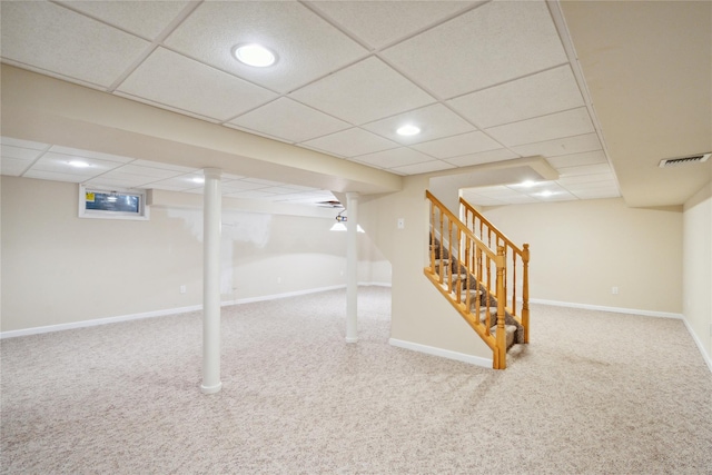 finished below grade area with a drop ceiling, baseboards, visible vents, stairs, and carpet floors
