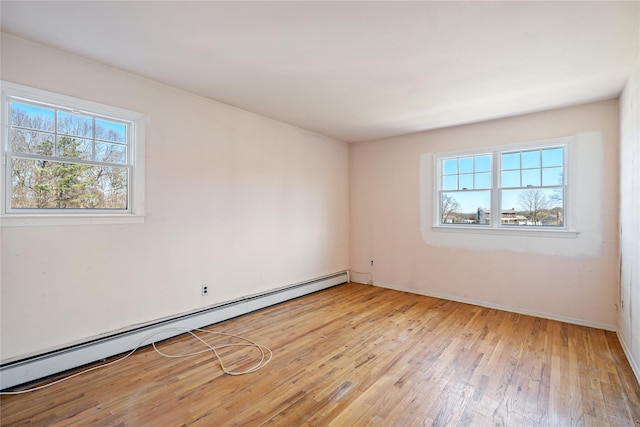 unfurnished room featuring a baseboard radiator, baseboards, light wood-style flooring, and plenty of natural light