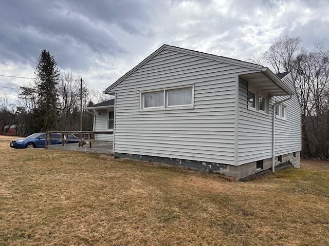 view of property exterior with a lawn