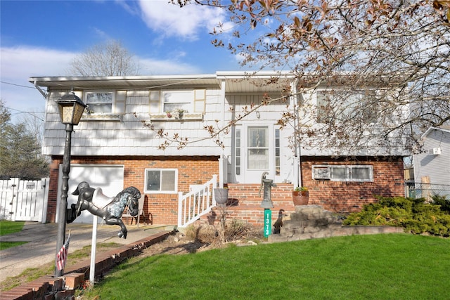view of front facade featuring a front lawn, brick siding, and fence