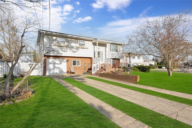 bi-level home with a front lawn, driveway, fence, a garage, and brick siding