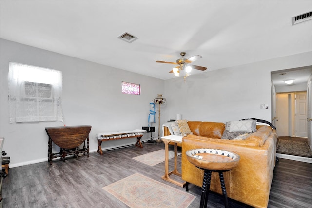 living room featuring wood finished floors, visible vents, a ceiling fan, and baseboards