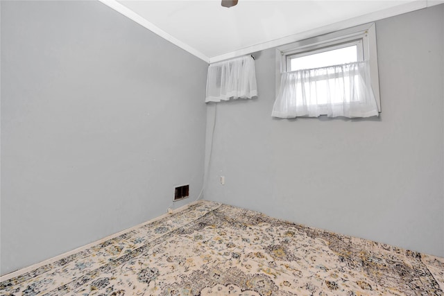 spare room featuring ornamental molding and visible vents