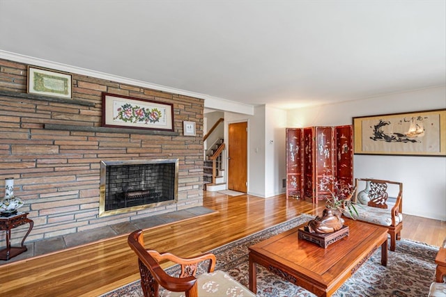 living room featuring a fireplace, wood finished floors, and stairway