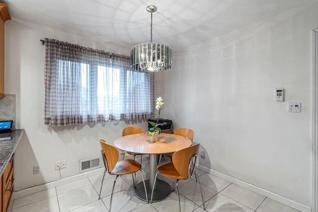 dining space with baseboards, visible vents, an inviting chandelier, and light tile patterned floors