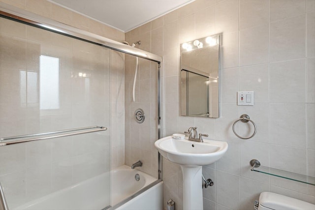 bathroom featuring toilet, enclosed tub / shower combo, tile walls, and decorative backsplash