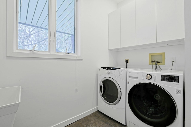 laundry area with baseboards, washer and clothes dryer, and cabinet space