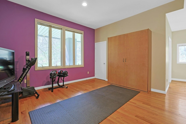 workout room featuring baseboards, recessed lighting, and wood finished floors