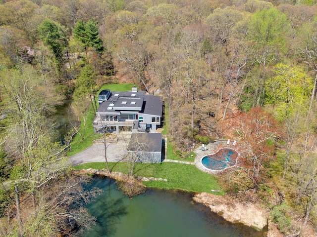 drone / aerial view featuring a water view and a view of trees