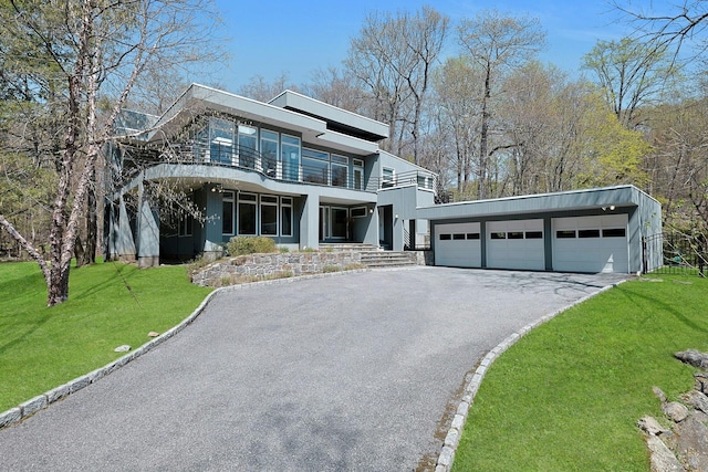 view of front of house with stucco siding, a balcony, and a front yard