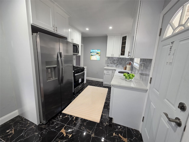 21741 112th Rd, Queens Village, NY 11429 - kitchen with backsplash, a sink, white cabinetry, stainless steel appliances, and marble finish floor