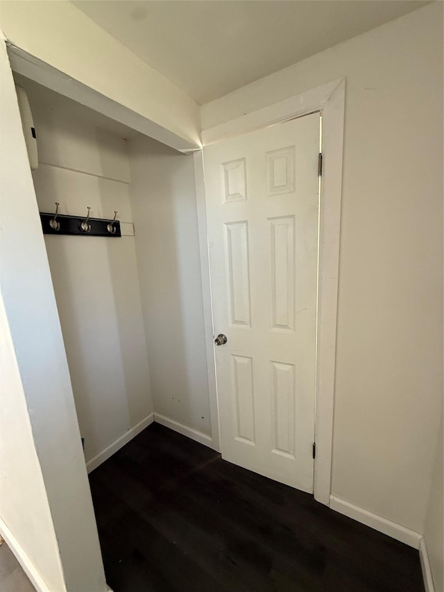 interior space with baseboards and dark wood-style flooring