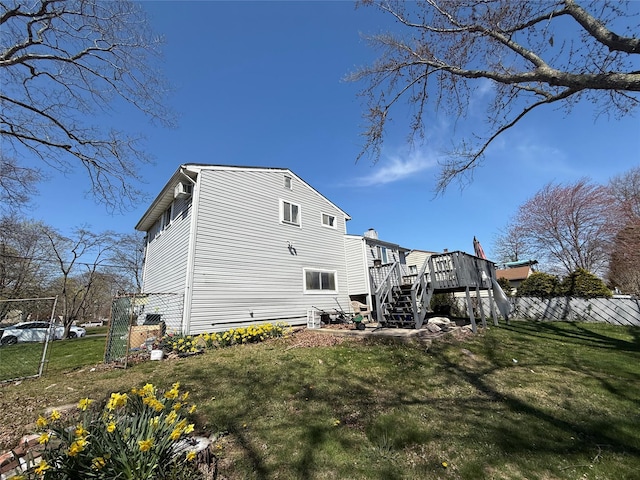 view of home's exterior featuring stairway, fence, a yard, and a deck