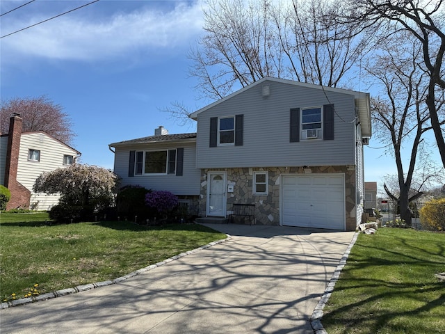 split level home featuring stone siding, a front lawn, and concrete driveway