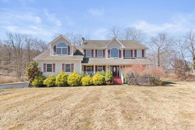 view of front of house with covered porch and a front lawn