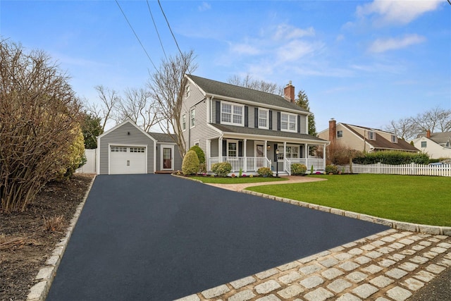 view of front of property with fence, a chimney, a porch, driveway, and a detached garage