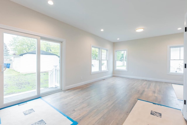 unfurnished living room featuring wood finished floors, baseboards, and recessed lighting