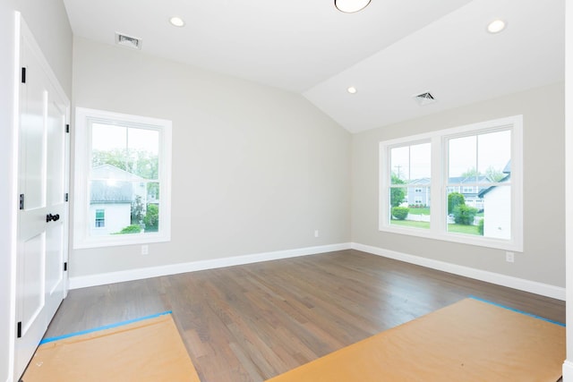 unfurnished room featuring plenty of natural light, recessed lighting, wood finished floors, lofted ceiling, and baseboards